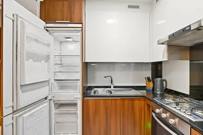 a kitchen with an open refrigerator and a sink at Relax in Comfort with Modern Amenities, Steps from Burj Khalifa and Dubai Mall in Dubai