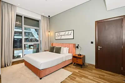 a bedroom with a bed and a large window at Relax in Comfort with Modern Amenities, Steps from Burj Khalifa and Dubai Mall in Dubai
