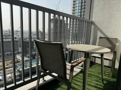 a table and chair on a balcony with a view at Luxury 1-Bedroom Apartment with Pool Access in DIFC, Dubai in Dubai