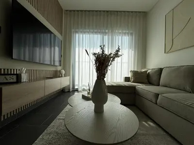 a living room with a vase with flowers on a table at Luxury 1-Bedroom Apartment with Pool Access in DIFC, Dubai in Dubai