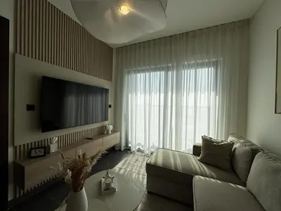 a living room with a couch and a flat screen tv at Luxury 1-Bedroom Apartment with Pool Access in DIFC, Dubai in Dubai