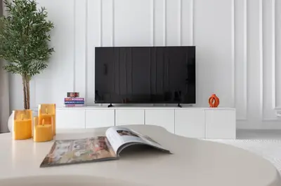 a living room with a television and a magazine on a table at Spacious 2BR in Sulafa Tower - Dubai Marina in Dubai
