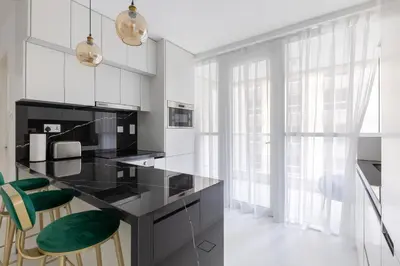 a kitchen with a black counter and green chairs at Spacious 2BR in Sulafa Tower - Dubai Marina in Dubai