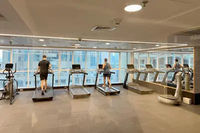 a group of people exercising on treadmills in a gym at Spacious 2BR in Sulafa Tower - Dubai Marina in Dubai