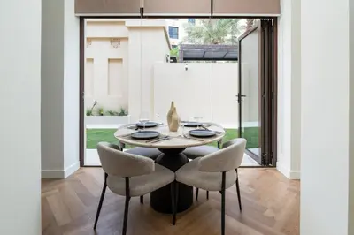 a dining room with a table and chairs at Newly Refurbished Luxury Garden Apartment with Burj Khalifa View and Direct Pool Access in Downtown Dubai in Dubai