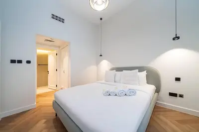 a bedroom with a large white bed with white pillows at Newly Refurbished Luxury Garden Apartment with Burj Khalifa View and Direct Pool Access in Downtown Dubai in Dubai