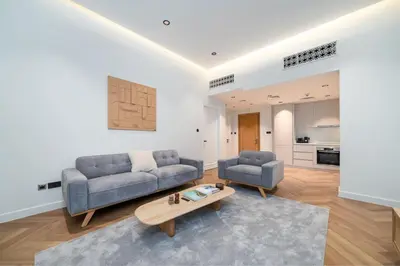 a living room with two couches and a coffee table at Newly Refurbished Luxury Garden Apartment with Burj Khalifa View and Direct Pool Access in Downtown Dubai in Dubai