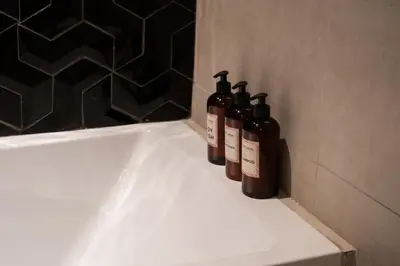 a group of three bottles sitting on a bathroom sink at Modern Studio with Balcony, Stunning City Views & Free Parking, Close to Dubai Mall in Dubai
