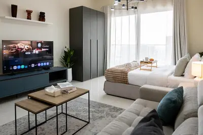 a living room with a couch and a tv at Modern Studio with Balcony, Stunning City Views & Free Parking, Close to Dubai Mall in Dubai