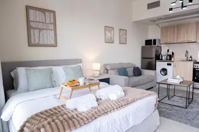 a bedroom with a large bed and a living room at Modern Studio with Balcony, Stunning City Views & Free Parking, Close to Dubai Mall in Dubai
