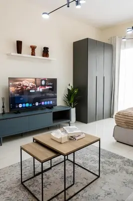 a living room with a tv and a coffee table at Modern Studio with Balcony, Stunning City Views & Free Parking, Close to Dubai Mall in Dubai