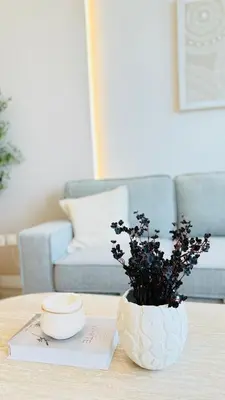 a table with a vase with flowers on it at Brand New 1BR, Downtown View, 5 Min Dubai Mall in Dubai