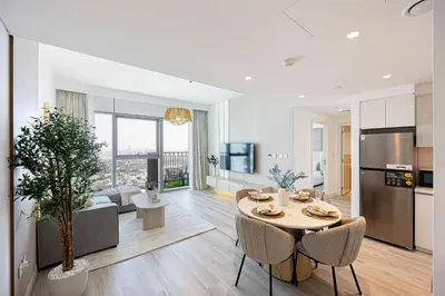 a kitchen and living room with a table and chairs at Brand New 1BR, Downtown View, 5 Min Dubai Mall in Dubai