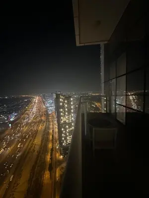 a view of a city at night from a building at Novotel Residence in Dubai