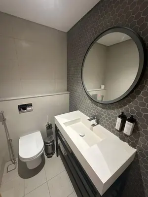 a bathroom with a sink and a toilet and a mirror at Novotel Residence in Dubai