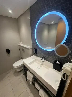 a bathroom with a sink and a toilet and a mirror at Novotel Residence in Dubai