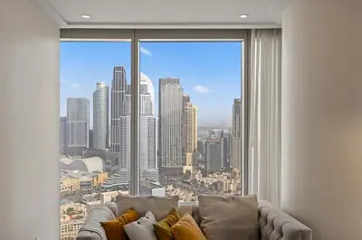 a living room with a couch and a large window at 2BR at Opera Grand, Fountain and Burj Khalifa Views in Dubai