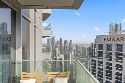 a balcony with chairs and a view of the city at 2BR at Opera Grand, Fountain and Burj Khalifa Views in Dubai