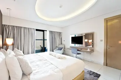 a bedroom with a large white bed and a desk at High-Rise Living - Paramount Tower - 1 bedroom in Dubai