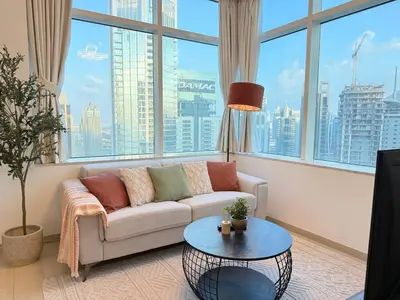 a living room with a couch and a large window at Peachy Mint - Luxury 1 BHK - Marina & Sea View in Dubai