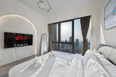 a bedroom with a white bed and a large window at Elegant High-Rise Escape with sea view by SoleaStay in Dubai
