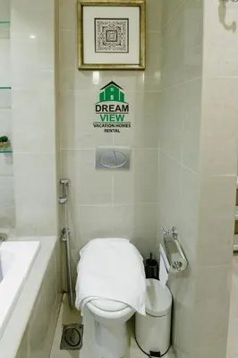a bathroom with a white toilet and a sink at Souk Al Bahar View Burj Khalifa and Fountains Dream View Holiday Homes in Dubai