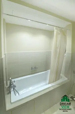 a bath tub in a bathroom with a mirror at Souk Al Bahar View Burj Khalifa and Fountains Dream View Holiday Homes in Dubai