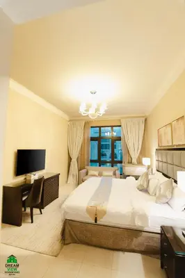 a bedroom with a bed and a desk and a television at Souk Al Bahar View Burj Khalifa and Fountains Dream View Holiday Homes in Dubai