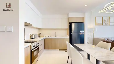a kitchen with a refrigerator and a table with chairs at Stylish2BR Apartment Iconic The Grand LH in Dubai