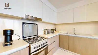 a kitchen with a stove top oven next to a sink at Stylish2BR Apartment Iconic The Grand LH in Dubai