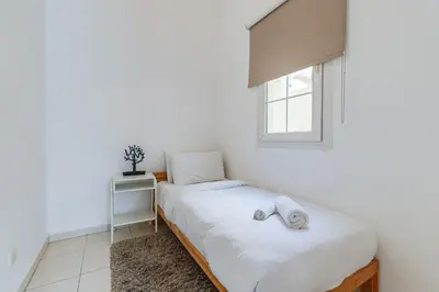 a white bedroom with a bed and a window at The Springs 8 - 2 Bedroom with Maids Room Villa - Allsopp & Allsopp in Dubai