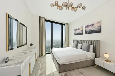 a white bedroom with a large bed and large windows at Stylish Urban Stay in Address JBR with Canal View in Dubai