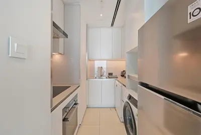 a kitchen with white cabinets and a washer and dryer at Stylish Urban Stay in Address JBR with Canal View in Dubai