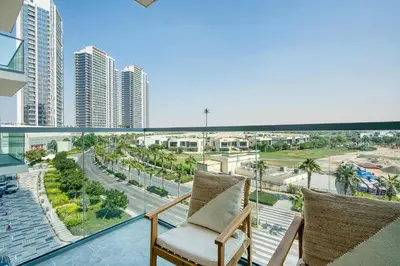 a balcony with two chairs and a view of a city at PVH - Modern 1BR with Golf Course View - Golf Gate in Dubai