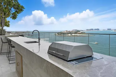 an outdoor kitchen with a television on a counter at Cozy 1BD Apartment in Grand Bleu, Emaar Beachfront in Dubai