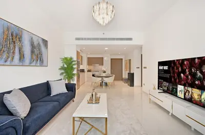 a living room with a blue couch and a tv at Cozy 1BD Apartment in Grand Bleu, Emaar Beachfront in Dubai