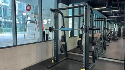 a gym with a row of tread machines at Maison Privee - Serene Studio Escape with Balcony in JVC in Dubai
