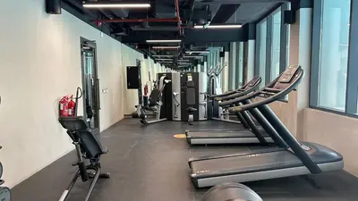 a gym with rows of treadmills and machines at Maison Privee - Serene Studio Escape with Balcony in JVC in Dubai