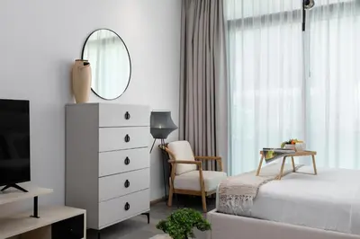 a bedroom with a bed and a mirror and a chair at Maison Privee - Serene Studio Escape with Balcony in JVC in Dubai