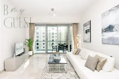 a white living room with a white couch and a table at Stunning 2BR Holiday Home JBR Views Dubai Marina in Dubai