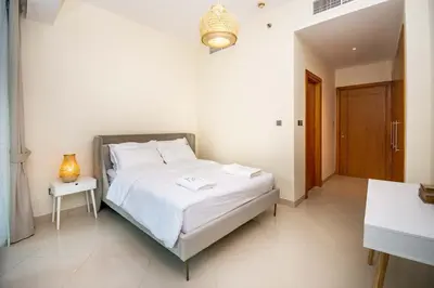 a bedroom with a white bed and a table at Stunning 2BR Holiday Home JBR Views Dubai Marina in Dubai