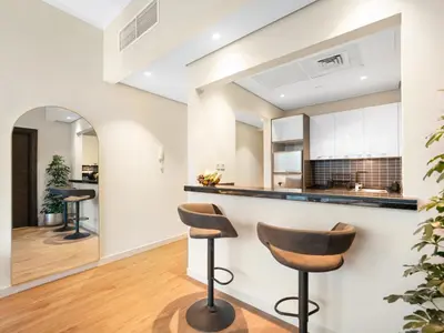 a kitchen and living room with stools at a counter at Livora Stays - Marina Promenade , Walk to JBR in Dubai