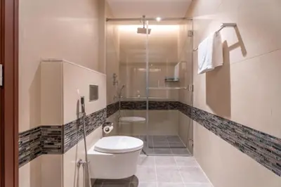 a bathroom with a toilet and a glass shower at GuestReady - 2BR City View | Canal | High Floor in Dubai