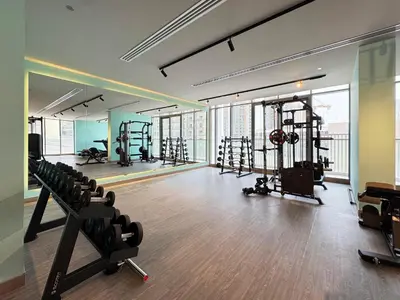 a gym with treadmills and machines in a building at 1BR with Huge Terrace & Pool View at JVC in Dubai