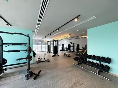 a gym with lots of equipment in a room at 1BR with Huge Terrace & Pool View at JVC in Dubai