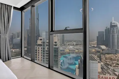 a hotel room with a view of a city at Direct Burj & Fountain Views - Designer 4BR Haven! in Dubai