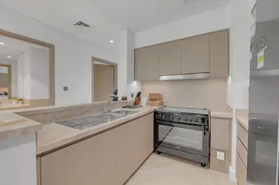 a kitchen with a sink and a stove at Direct Burj & Fountain Views - Designer 4BR Haven! in Dubai