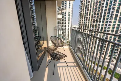 two chairs on a balcony with a view of buildings at Apartment with Stunning Canal Views, Just Minutes from Dubai Mall and Burj Khalifa - 17 Icon Bay, Dubai Creek Harbour by Deluxe Holiday Homes in Dubai