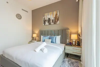 a bedroom with a large white bed with blue pillows at Apartment with Stunning Canal Views, Just Minutes from Dubai Mall and Burj Khalifa - 17 Icon Bay, Dubai Creek Harbour by Deluxe Holiday Homes in Dubai