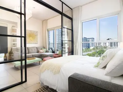 a bedroom with a large bed and a living room at Modern & Stylish Stay in 1BR Socio Dubai Hills in Dubai